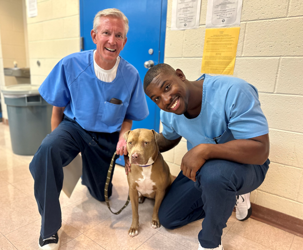 Dog trainers and their graduate at CSP-Corcoran. 