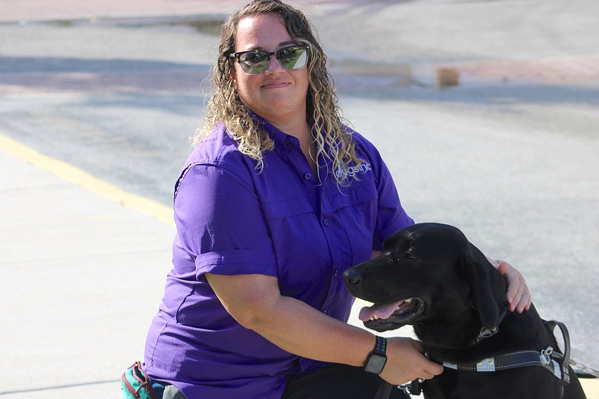 East County's Carley Crawford gives Wilco positive reinforcement after a Dogs Inc. training session at Main Street at Lakewood Ranch Monday.