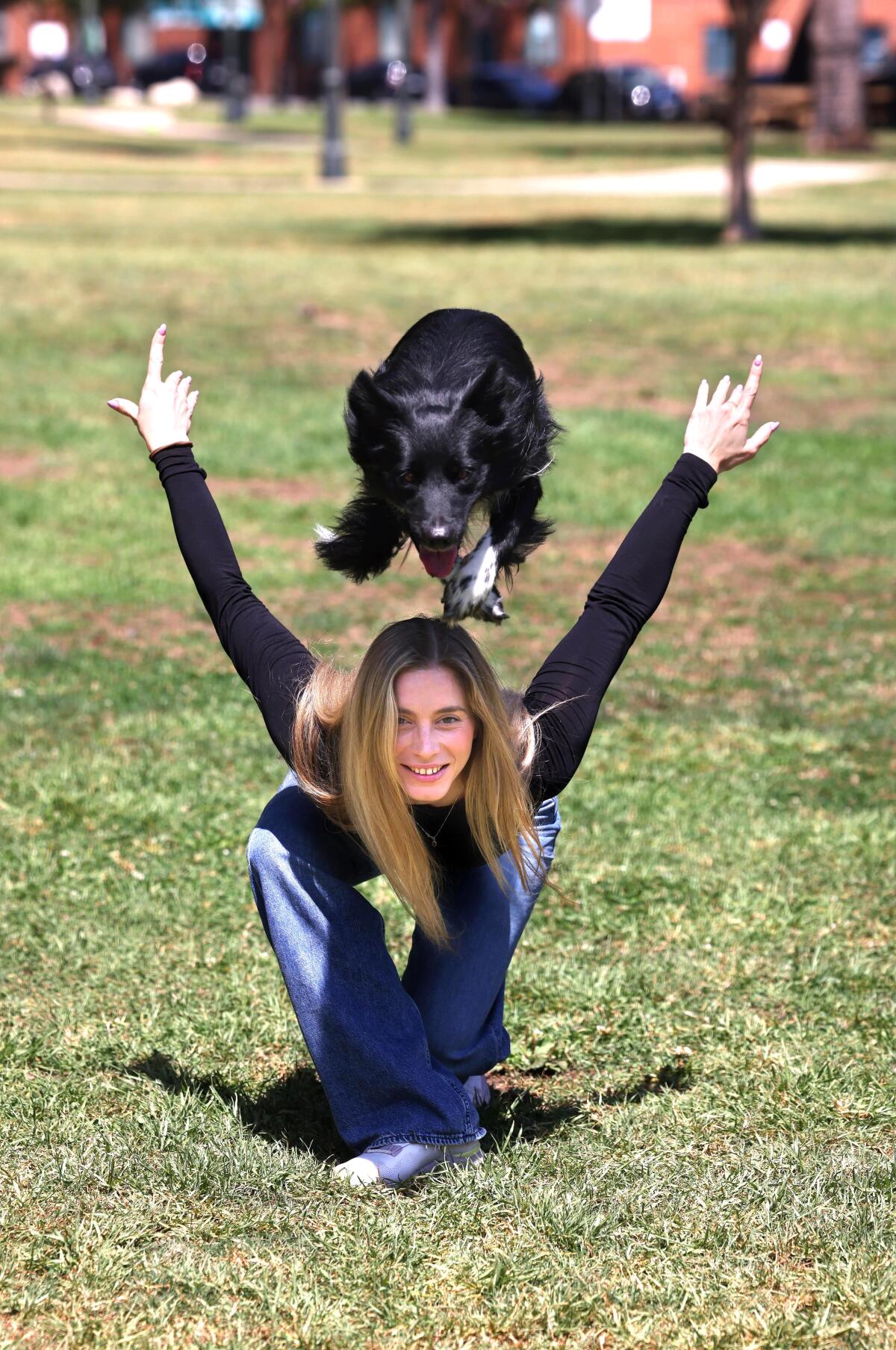 Woman with dog jumping over her back