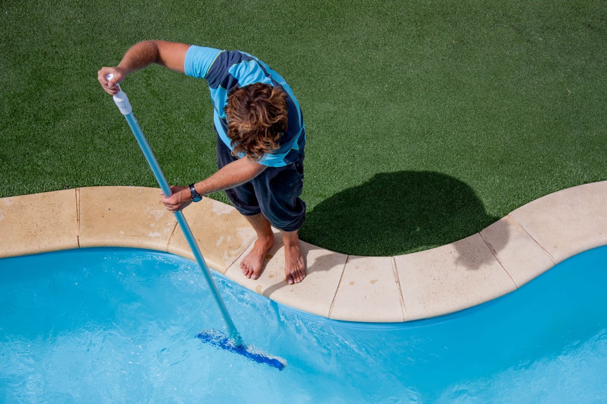 man cleaning a pool