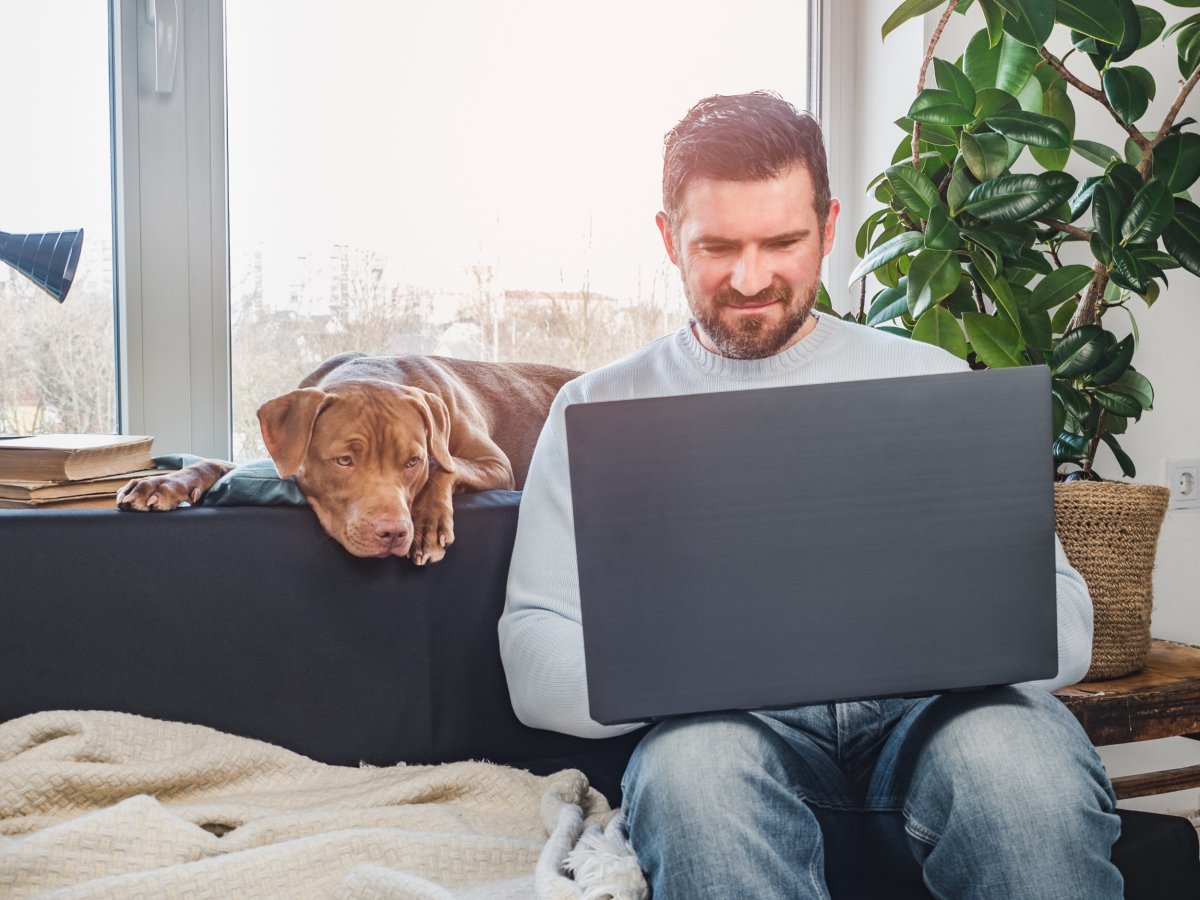 Man working with dog behind him