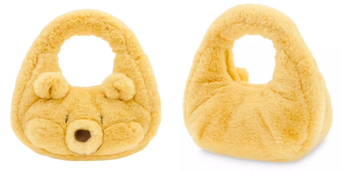 A plush, yellow handbag resembling Pooh's head, with small ears and a brown nose on one side. The other side is plain without any facial features, making it a subtle nod to Disney Plush Handbags.