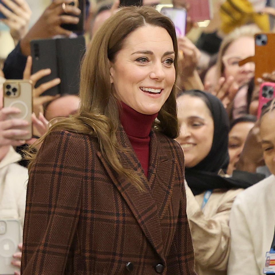  Princess Kate in front of a crowd in London wearing a plaid coat with an asprey bag. 