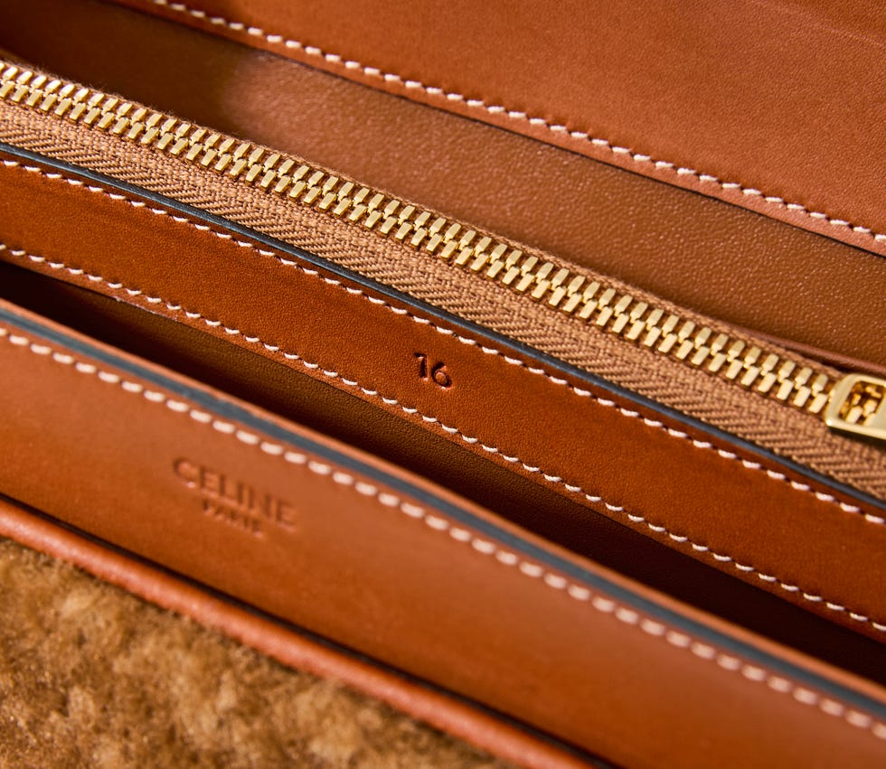 Close-up view of a luxury bag's interior featuring zippers and leather details.