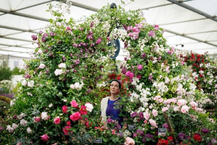 A woman posing under a huge display of roses