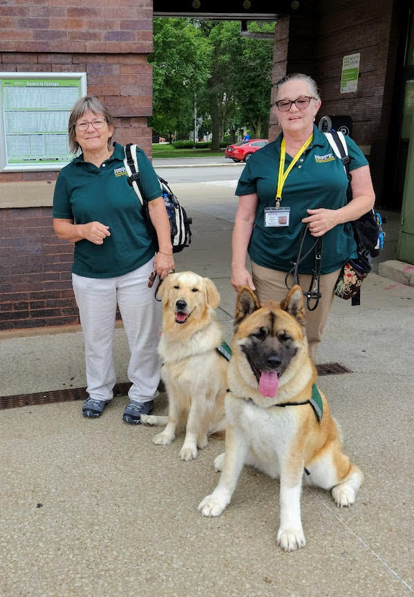 Janel Zuranski of Aurora and her dog Moose, left, and Heather Pontious of Naperville and her dog Kami wait at the Naperville train station recently. Both women and their dogs are part of HOPE, a national organization that provides animal assisted support for those in a crisis. (Janel Zuranski)