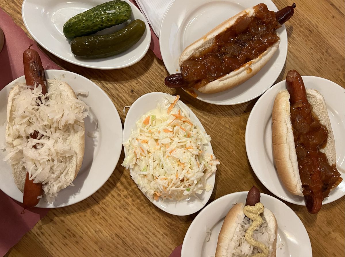 Hot dogs, sauerkraut, and pickles on paper plates. 