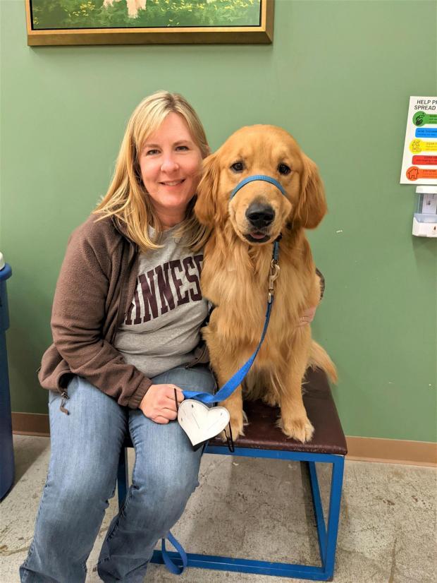 Melissa Hortman sits next to a golden retriever.
